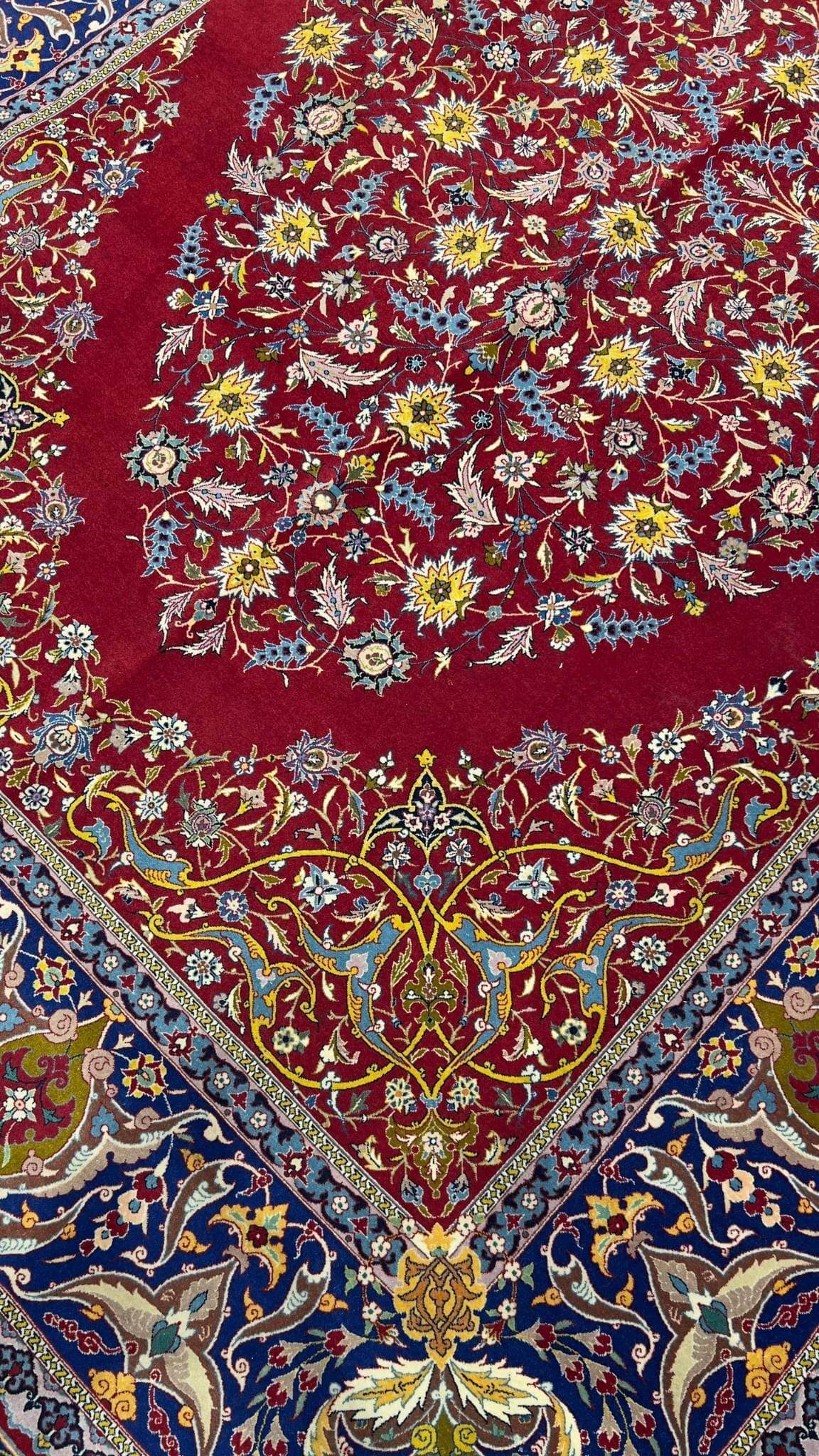 "Detailed view of antique red rug from Isfahan with intricate floral motifs"